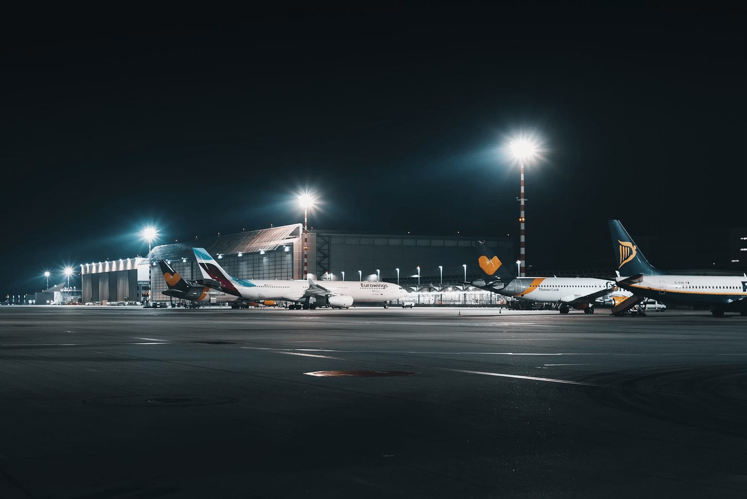 Aircraft parked outside an airport hangar at night